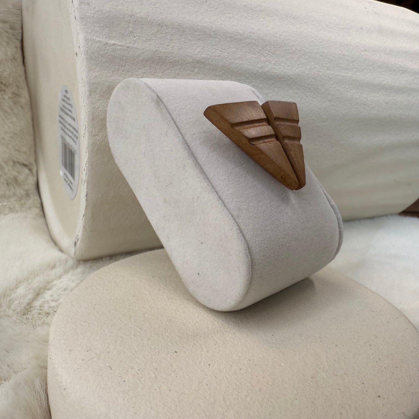 Close-up of smooth apple wood grain on handcrafted earrings, showing natural reddish tones and fine texture.