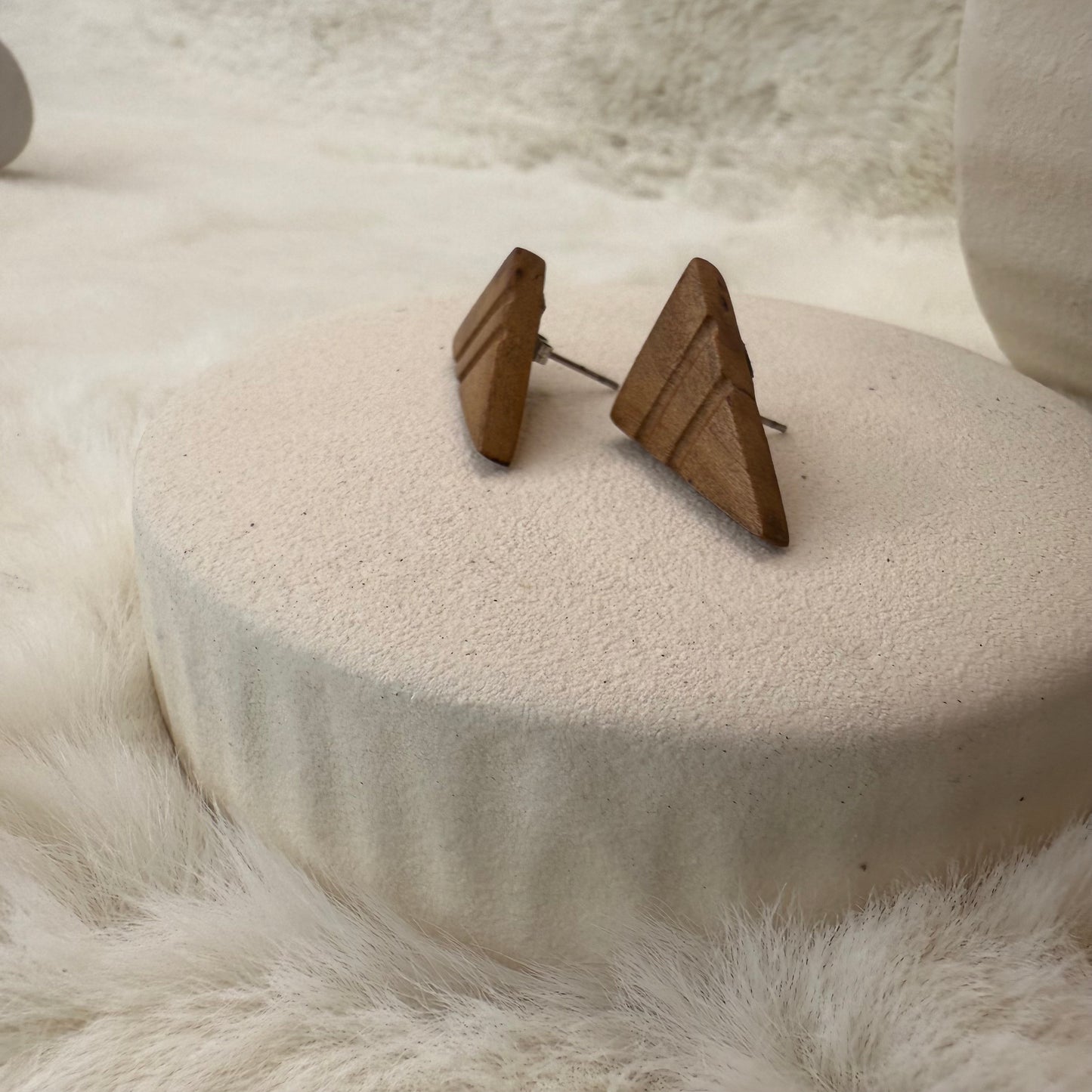 Handcrafted apple wood earrings in geometric triangle shape, minimalist natural jewelry on neutral background.