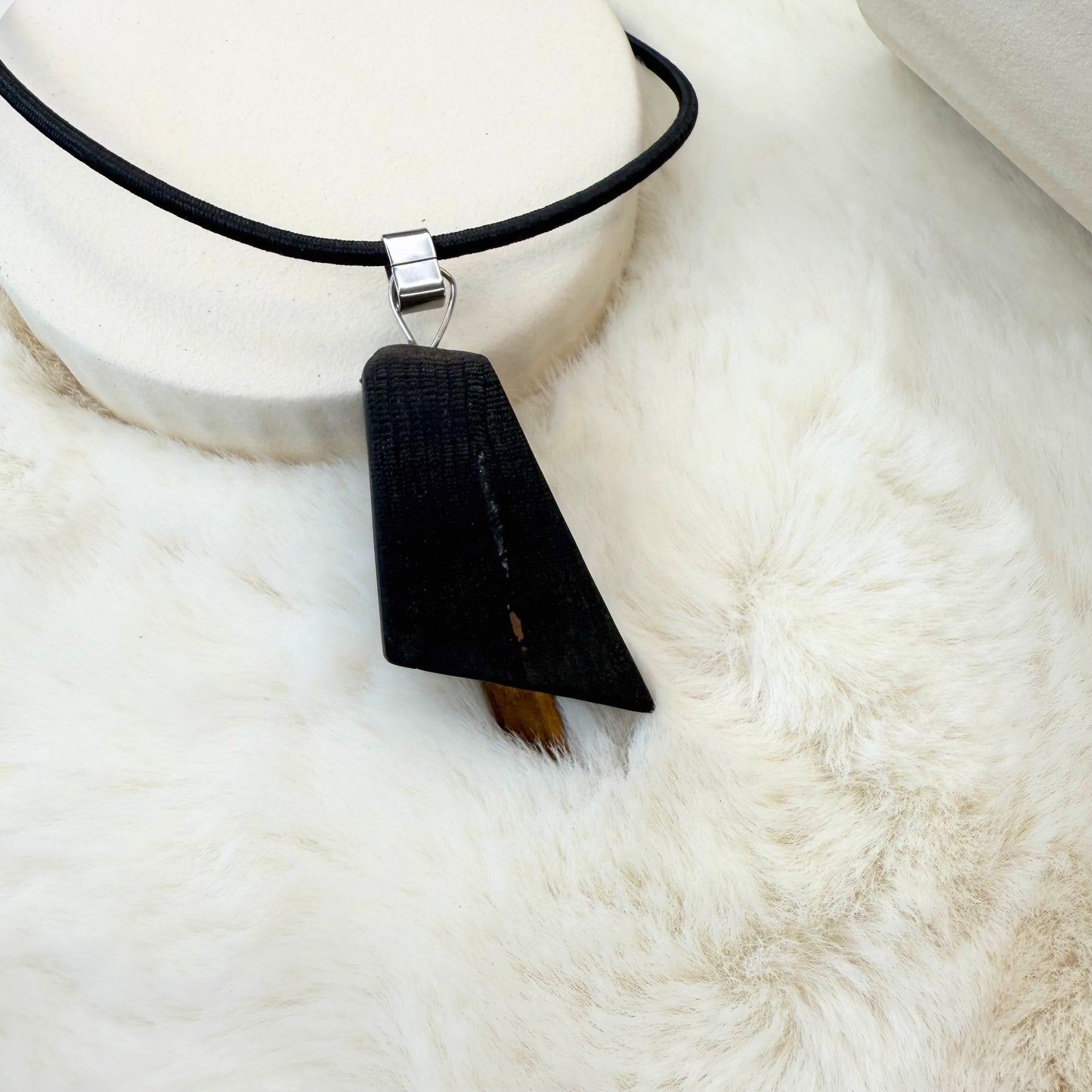 Natural wood pendant necklace resting on wooden surface