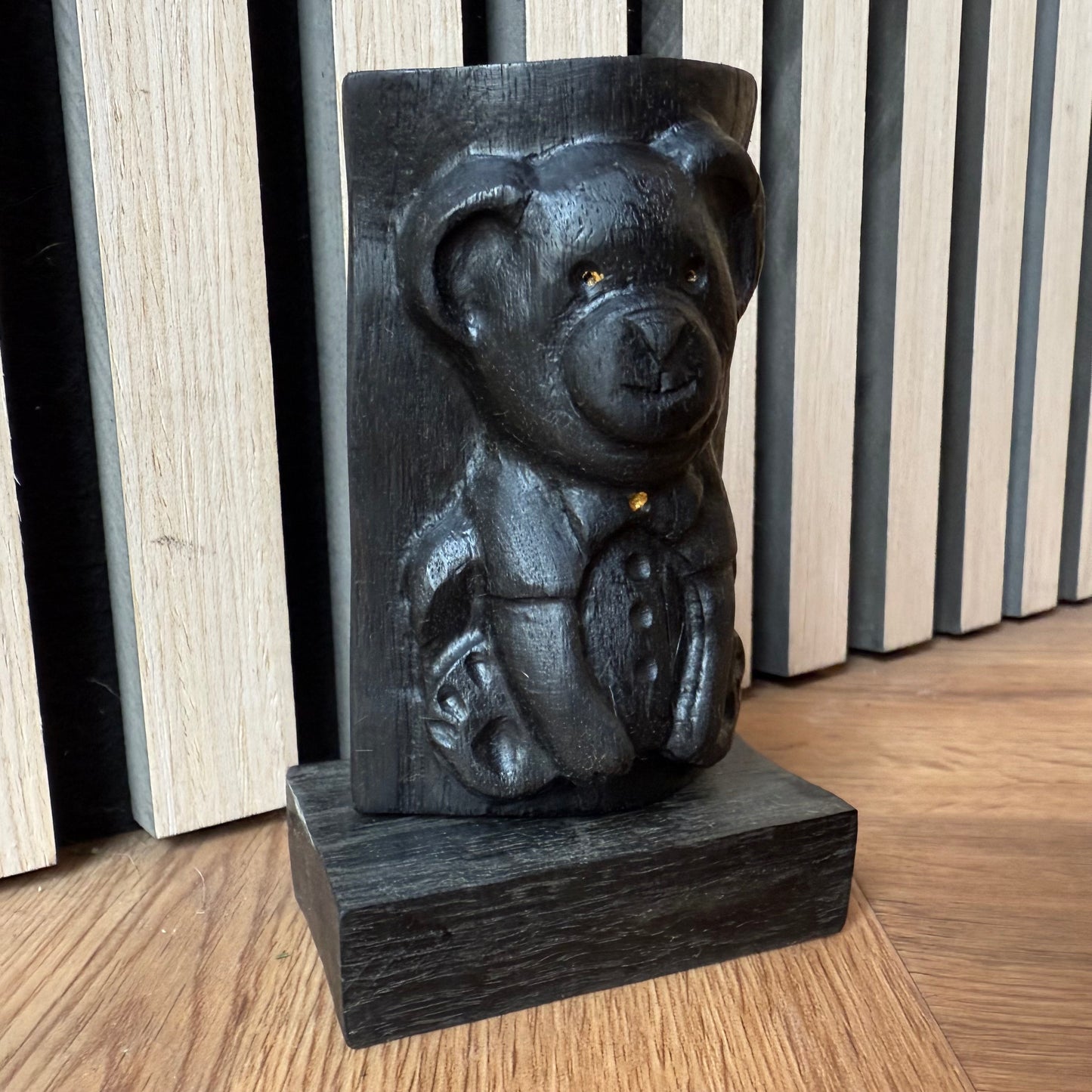 Handmade bog oak bear figurine placed on a wooden surface