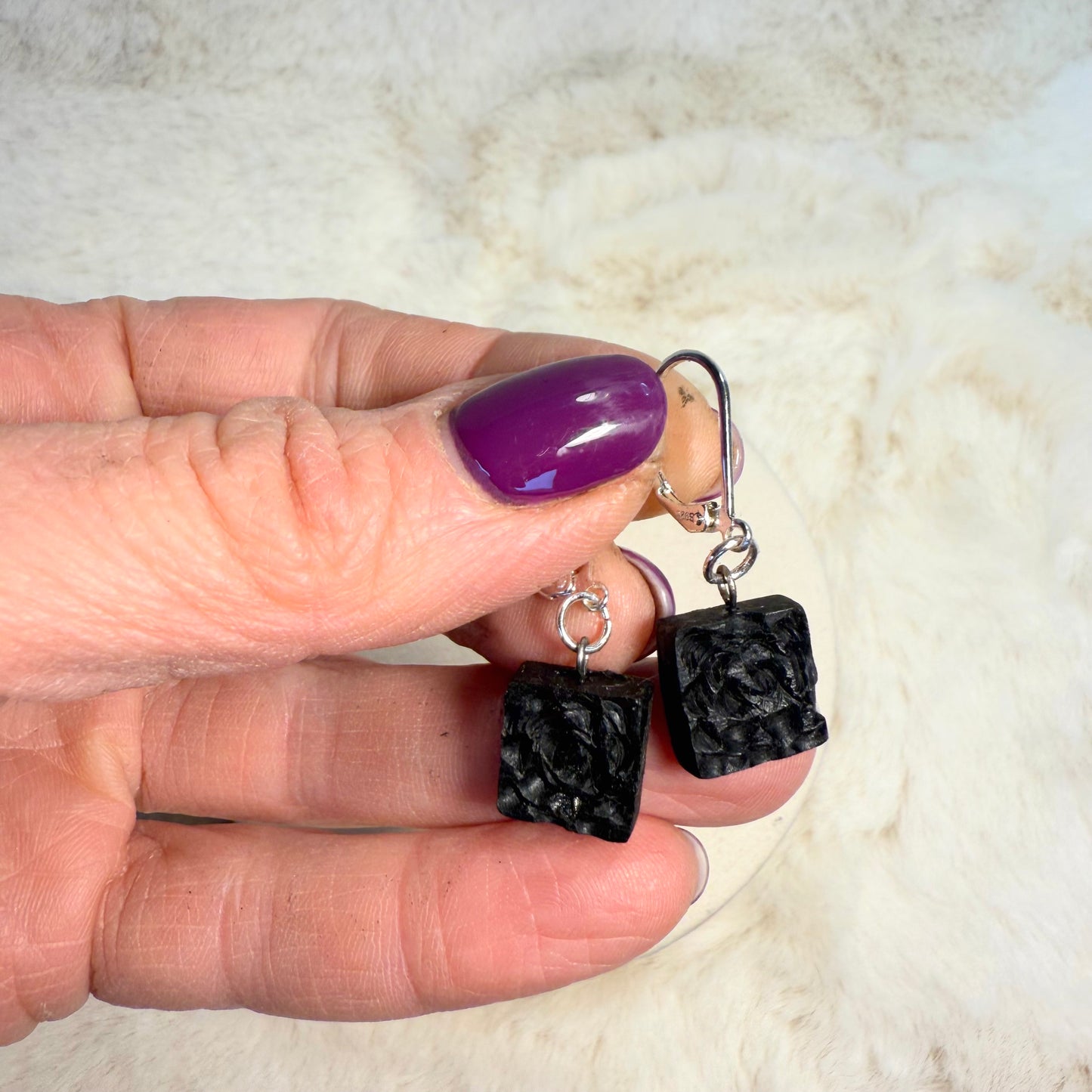 Close-up of floral engraved bog oak earrings with silver hooks