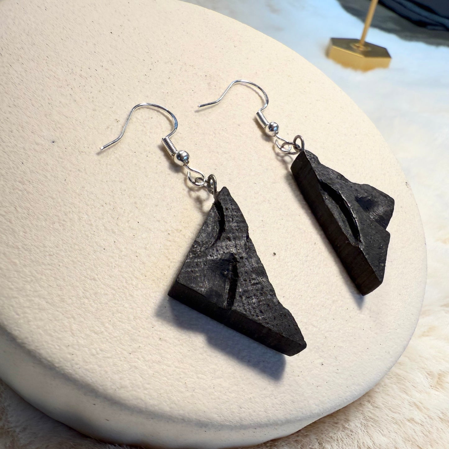 Detailed view of dark oak wood grain and surgical steel hook.