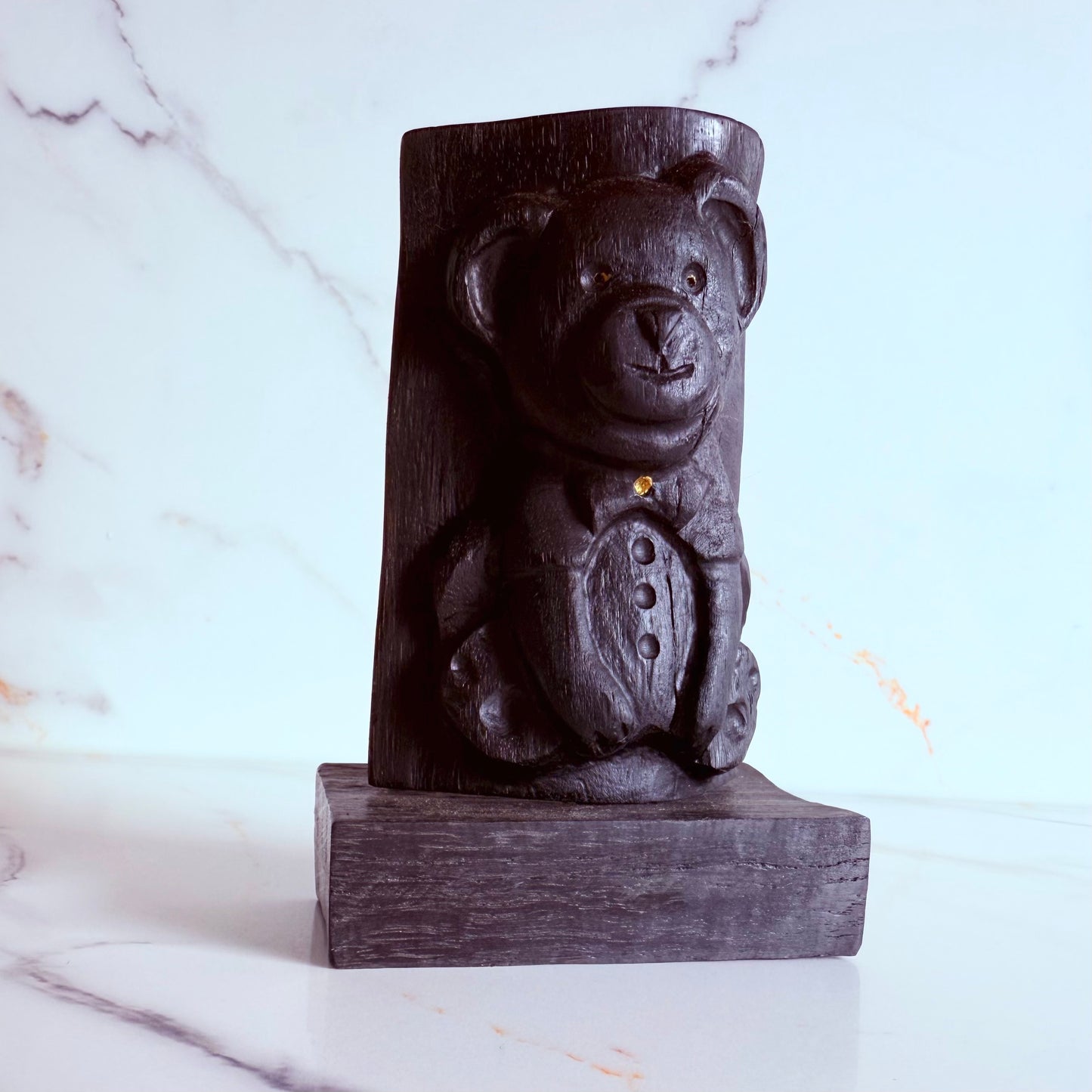 Elegant wooden bear sculpture standing upright on a neutral background