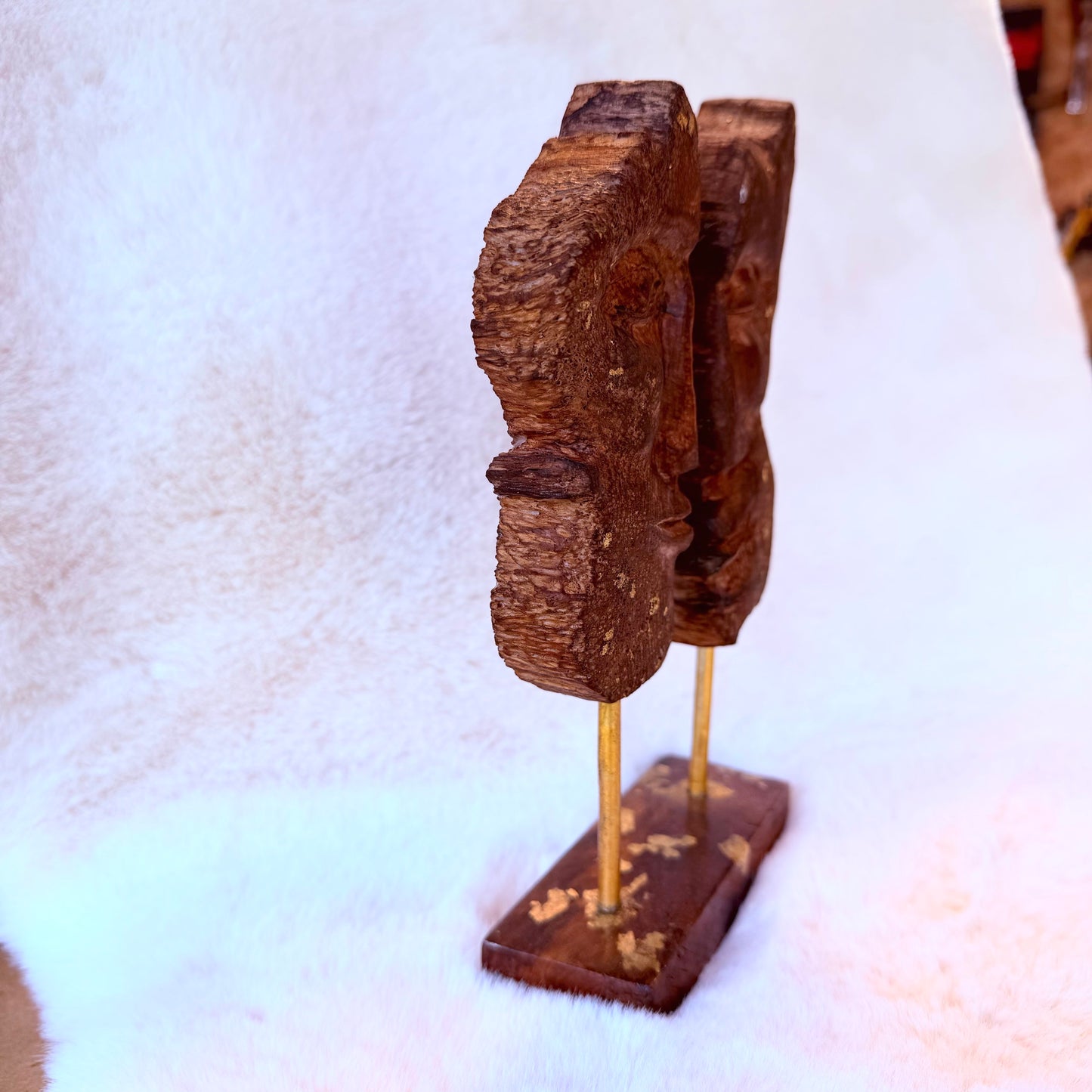 Natural wood sculpture featuring abstract faces, hand-carved finish