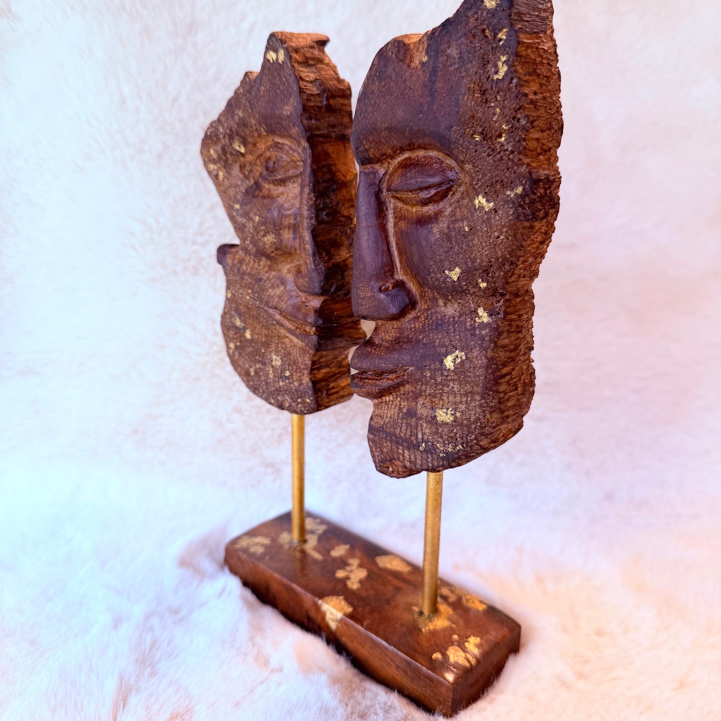 Close-up of dual-face wood carving showing natural grain texture