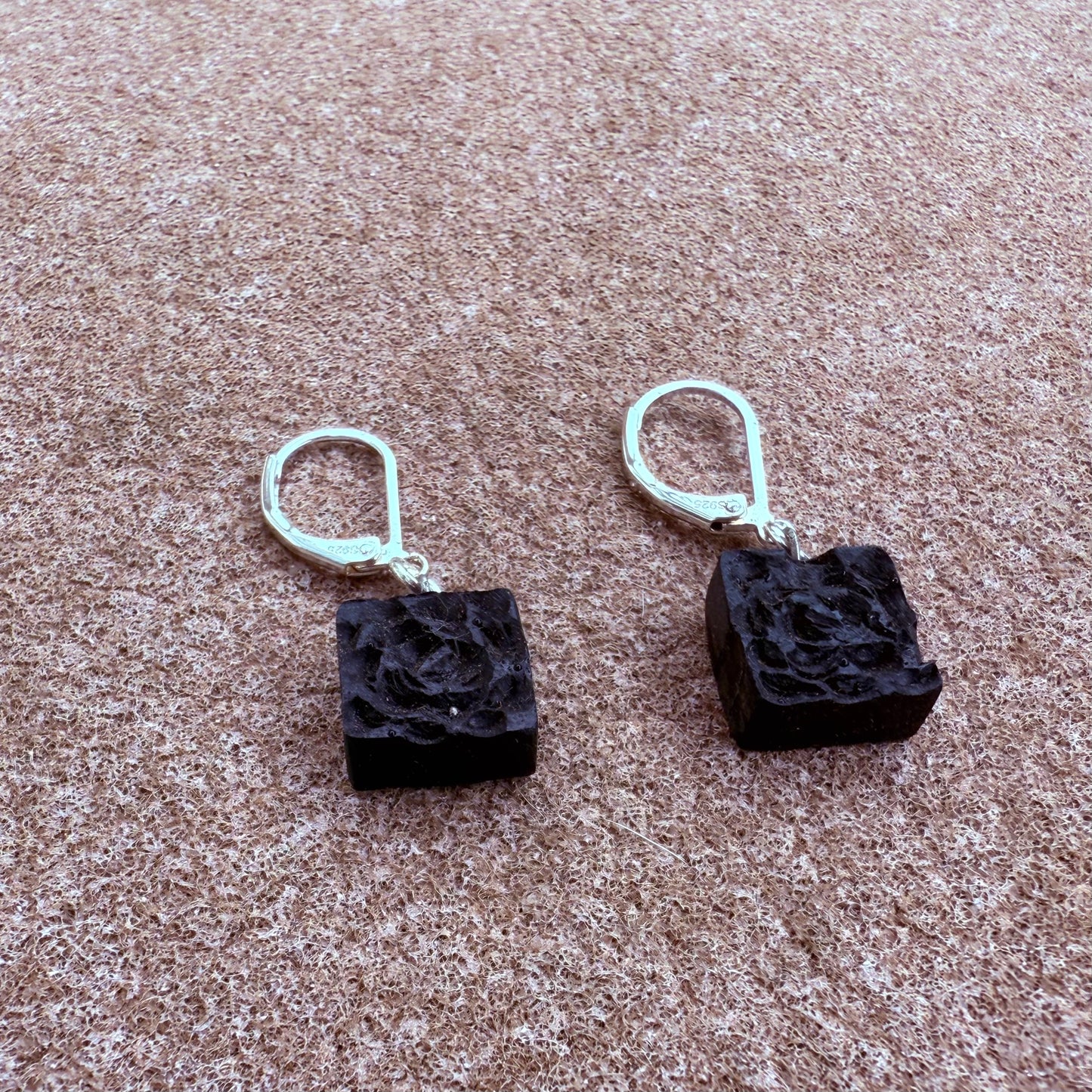 Natural black oak earrings photographed on linen fabric