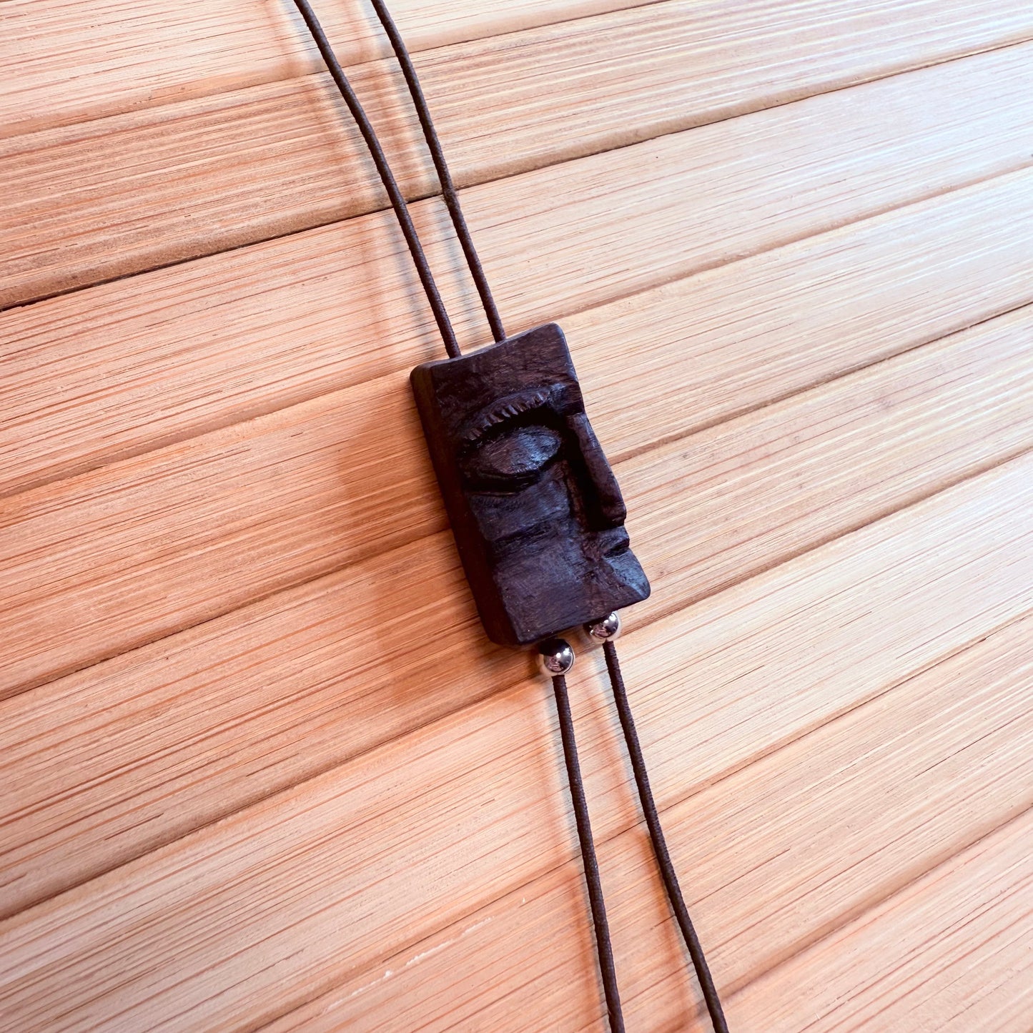 Jewellery piece made from ancient oak preserved in peat bogs, displayed flat with natural lighting
