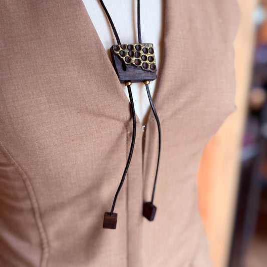 Close-up of handcrafted bog oak pendant on adjustable leather cord, with gold stainless steel bead