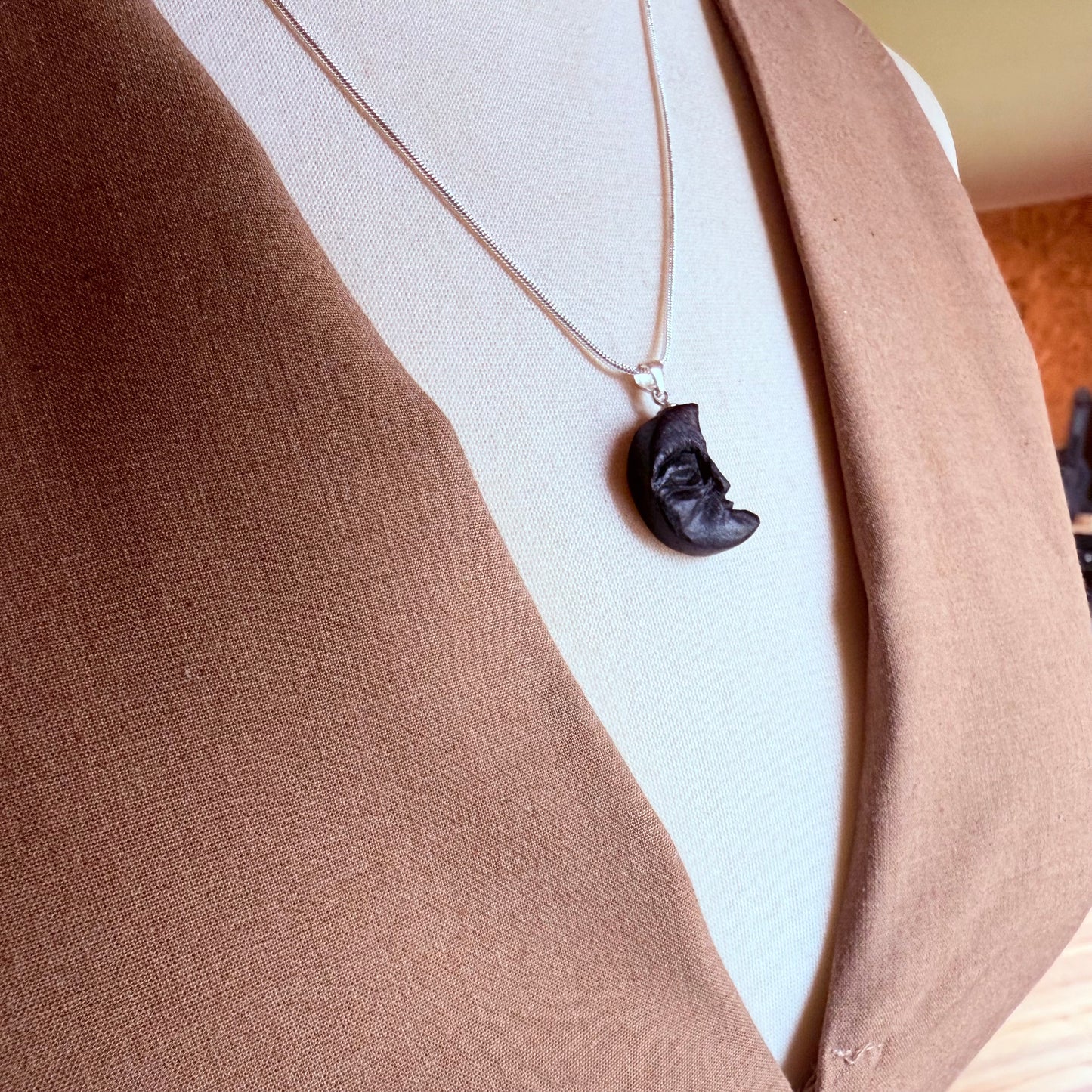 Dark wood crescent pendant hanging from silver chain – gothic forest jewelry