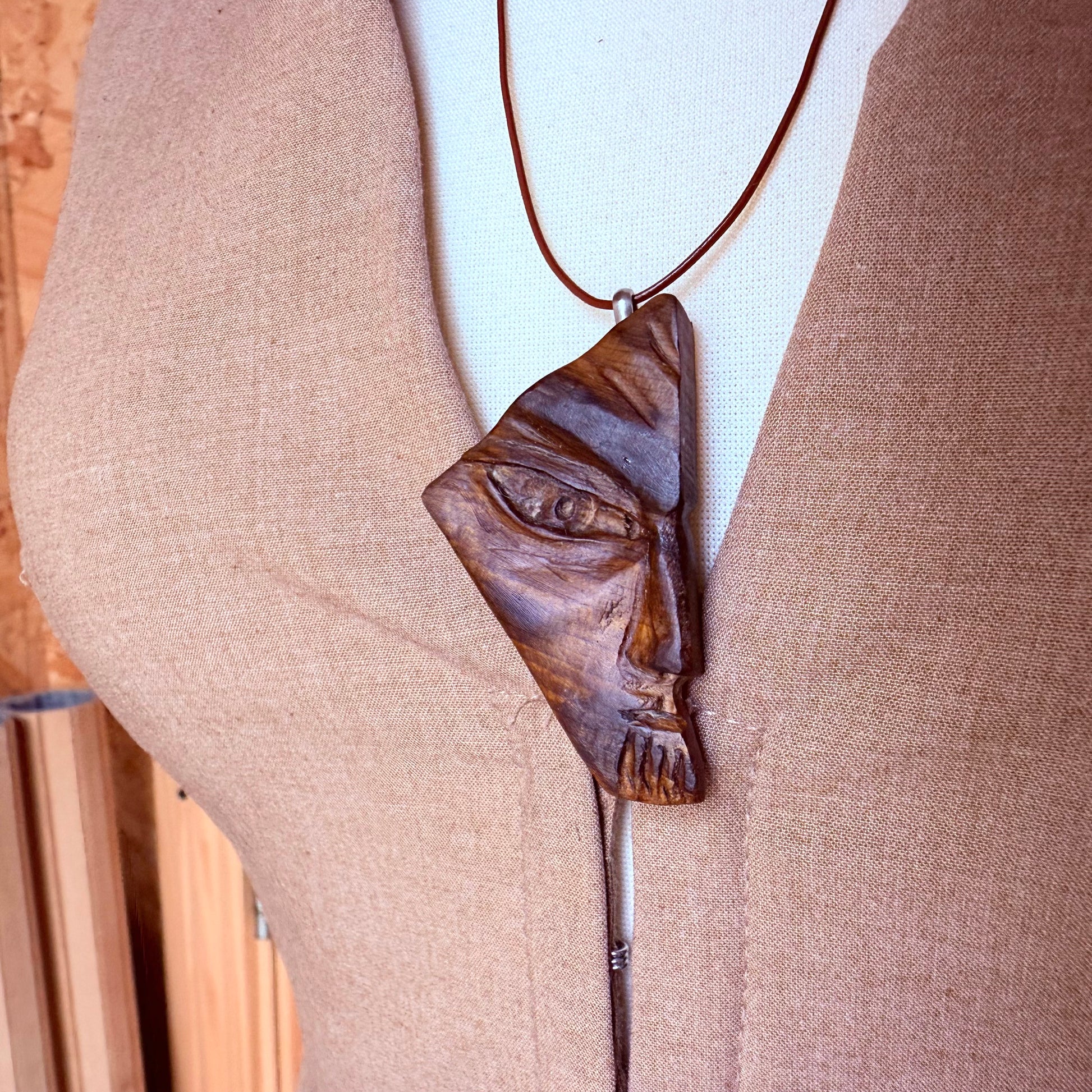 Wooden pendant shaped like a face