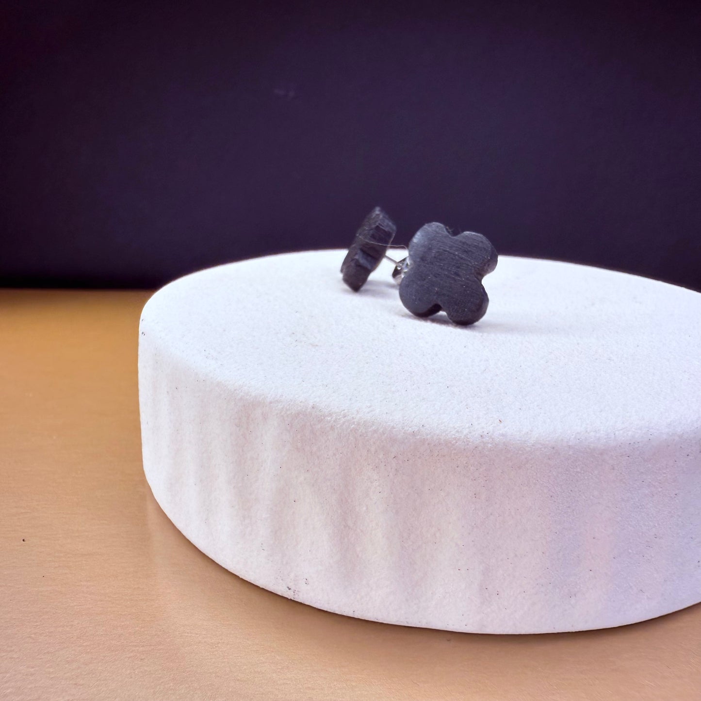 Close-up view of dark wood bog oak stud earrings, featuring a clover design for a nature-inspired look.