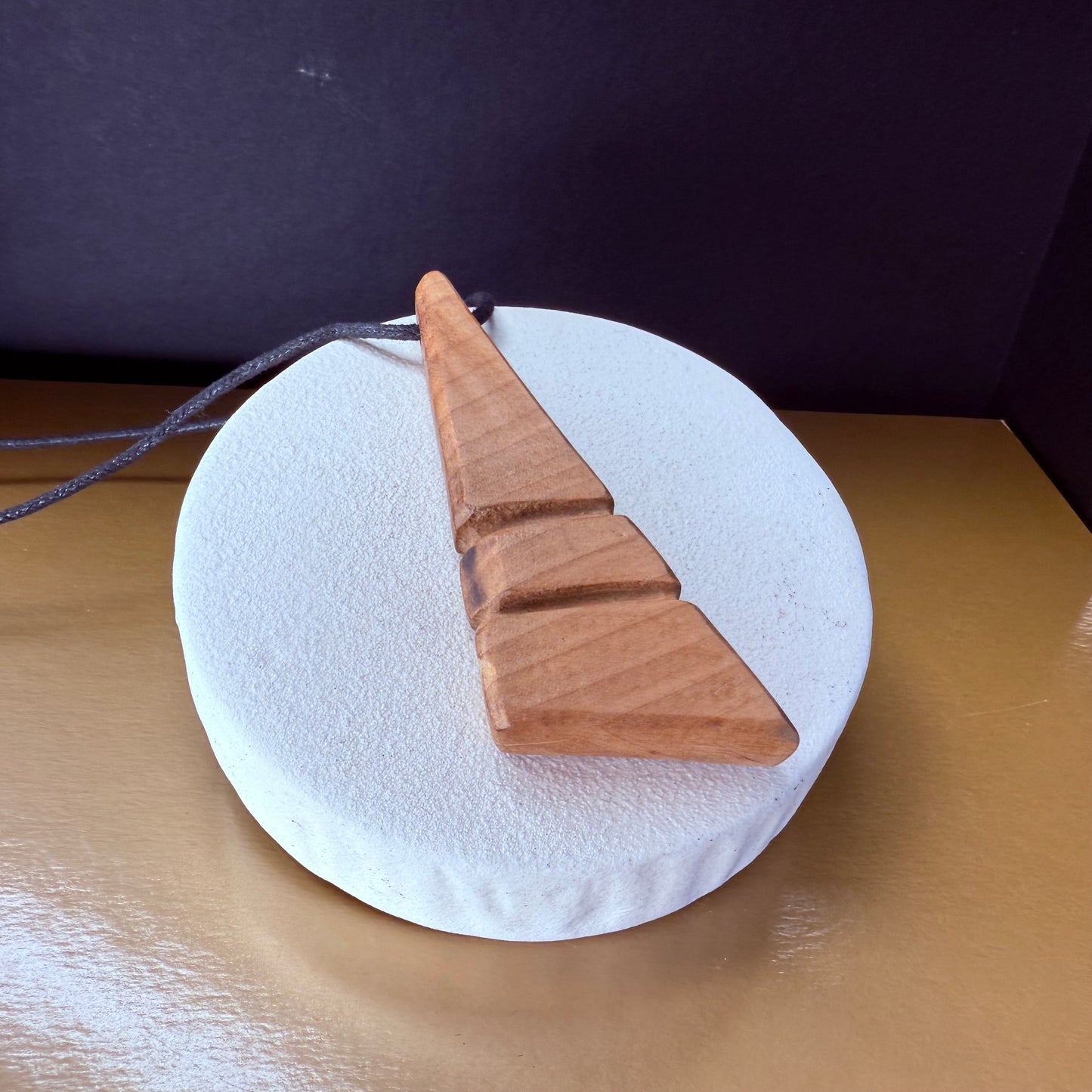 Eco-friendly handmade apple wood pendant necklace with natural wooden beads, close-up artistic shot