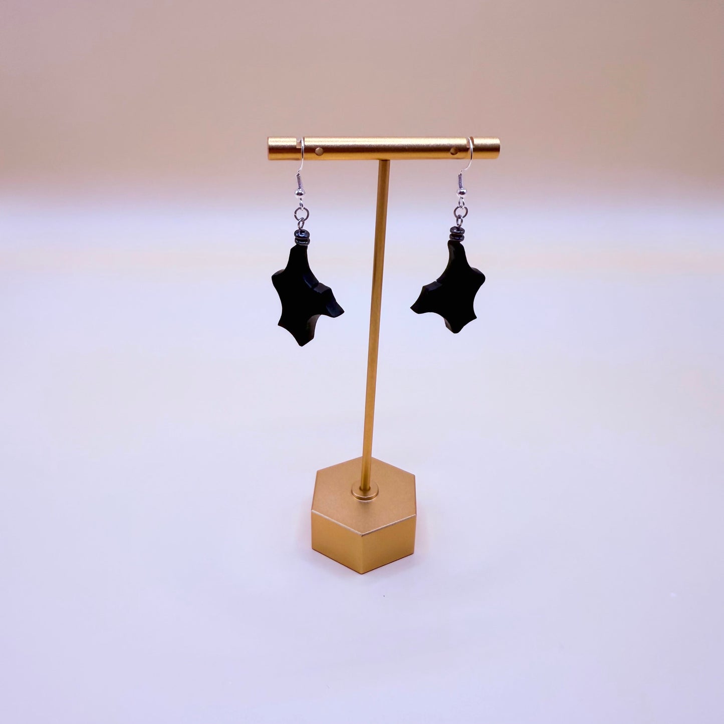 Close-up detail showing the dark gray hematite bead and stainless steel hook on the bog oak earrings.