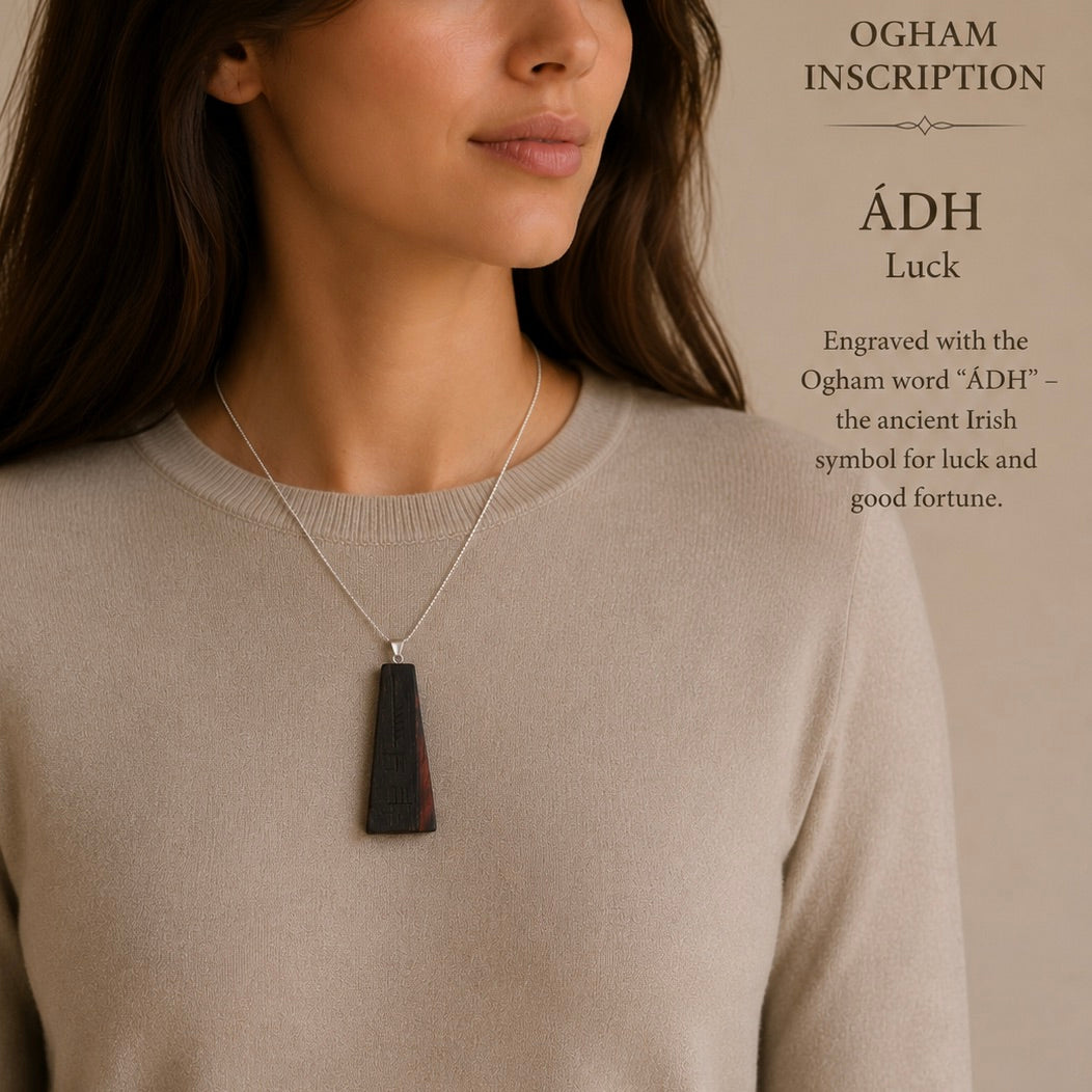 Woman wearing a necklace with an Ogham inscription pendant, set against a neutral background.