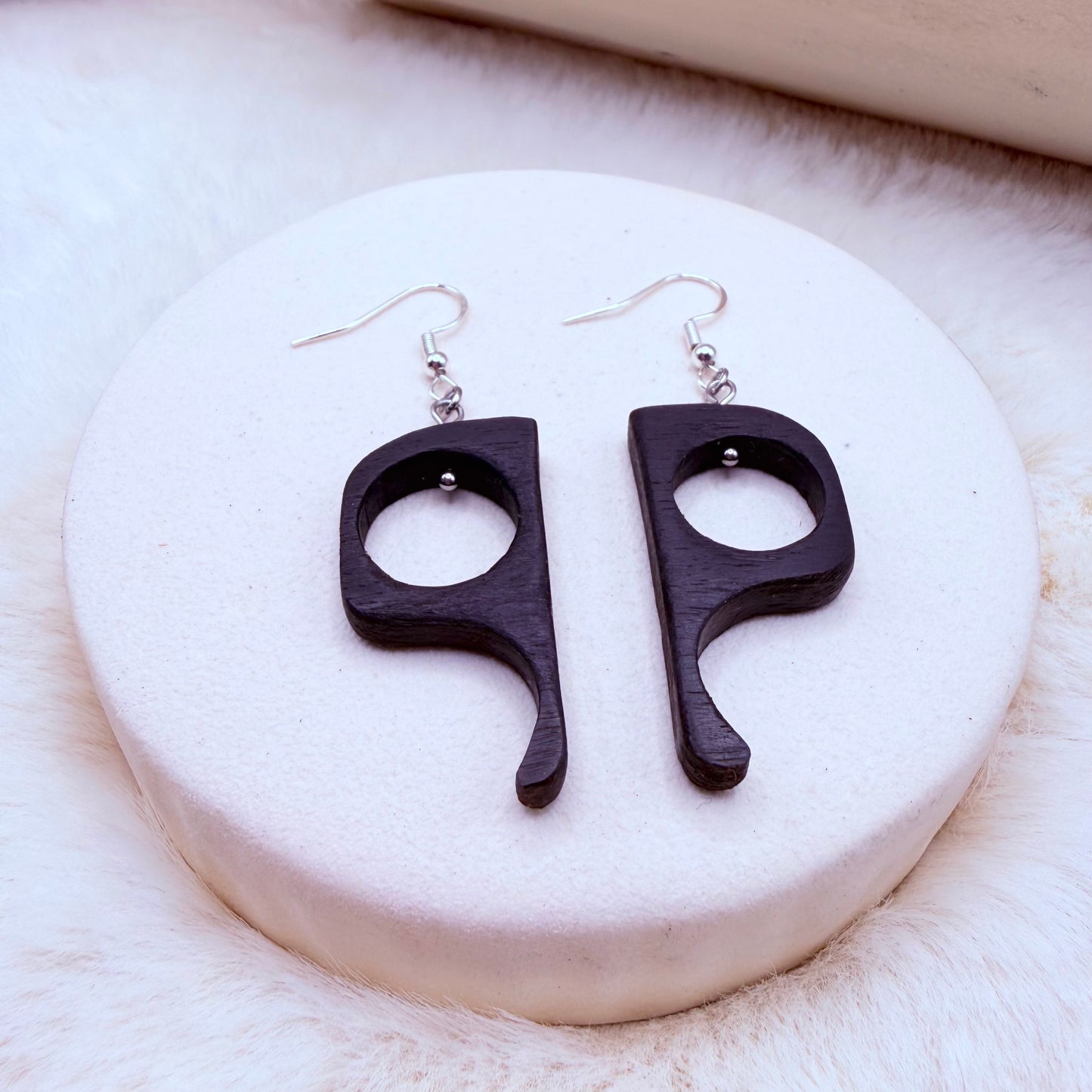 Black earrings shaped like question marks 