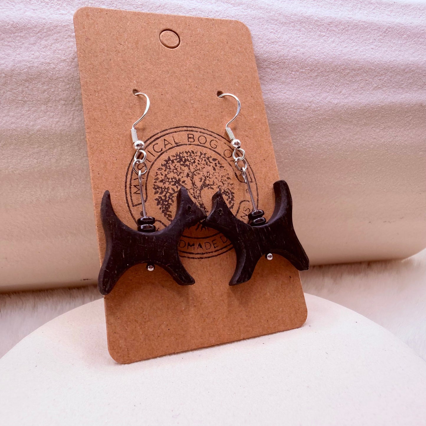 Handmade bog oak and hematite earrings shown on jewelry stand.