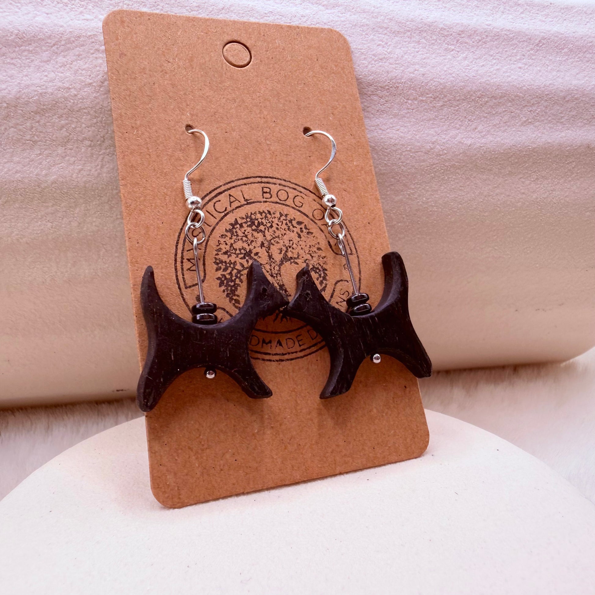 Handmade bog oak and hematite earrings shown on jewelry stand.