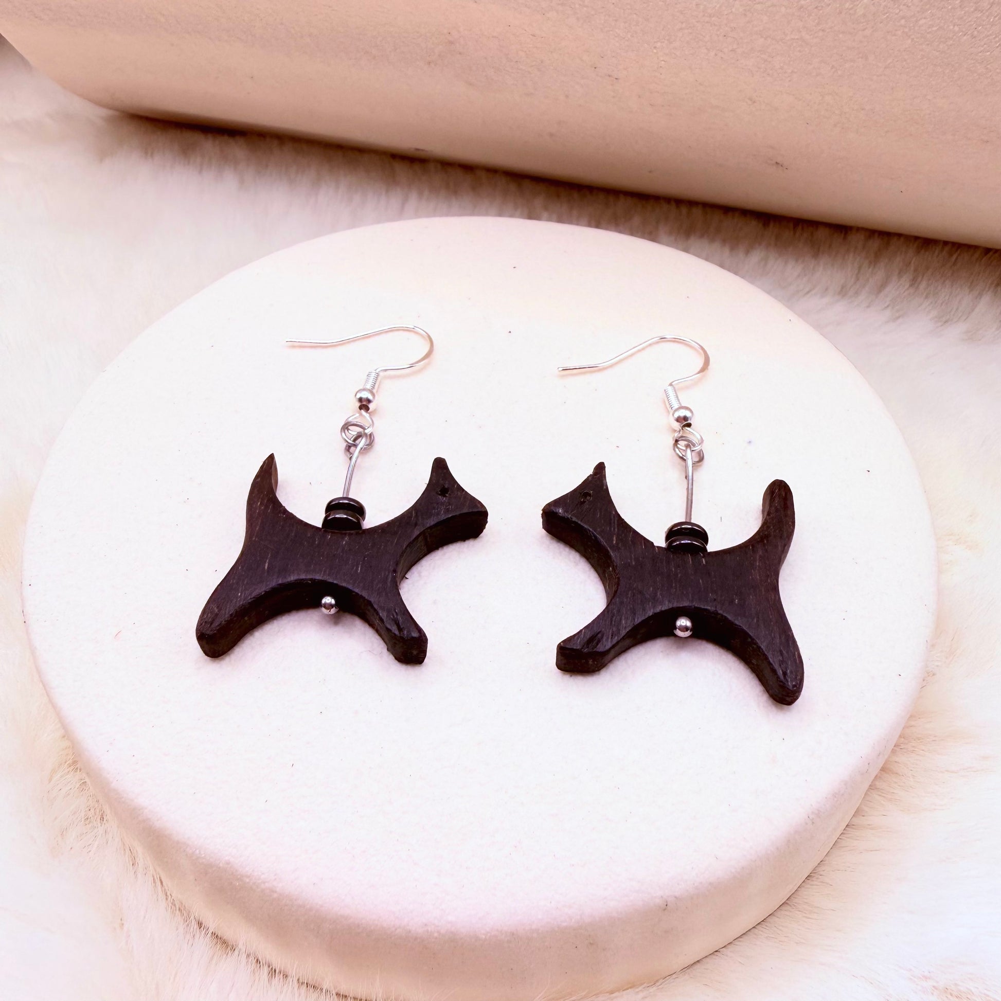 Lightweight natural wood and hematite statement earring hanging from ear hook.