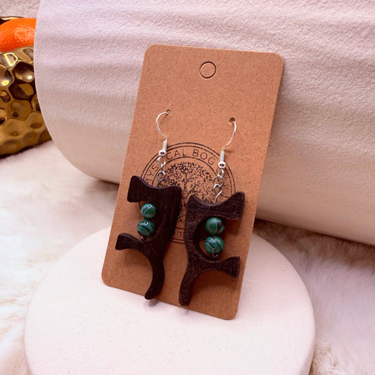 Handmade bog oak and malachite wooden earrings on neutral background