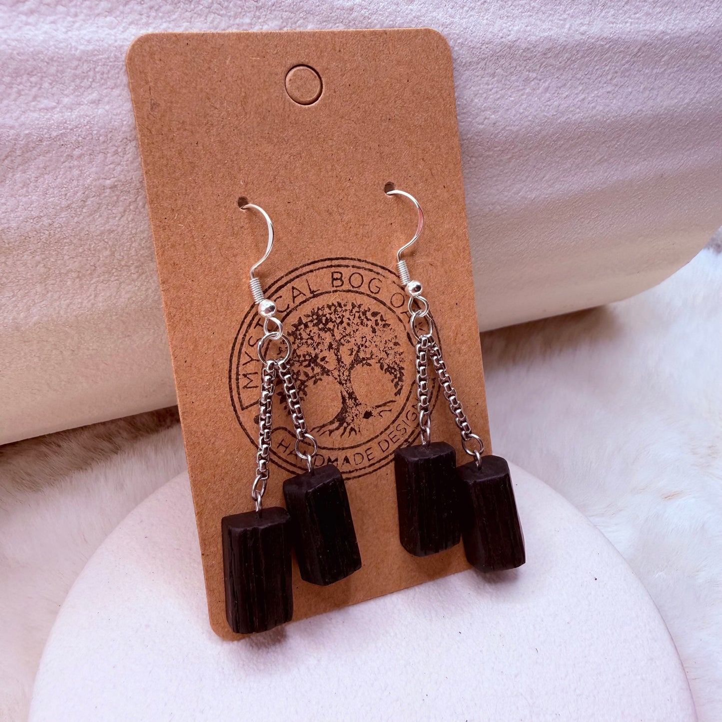 Handcrafted bog oak earrings shown worn on ear – natural wood jewelry look