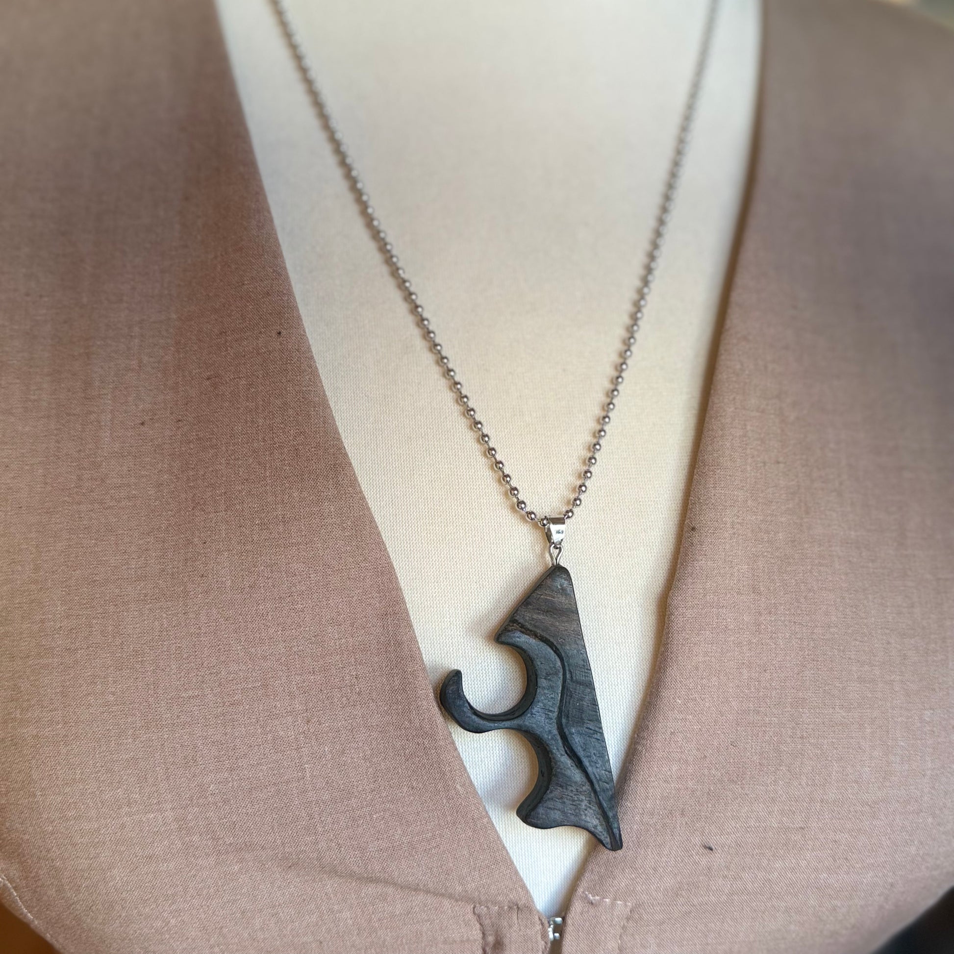 Handmade bog oak wood necklace with sculptural minimalist pendant on dark background