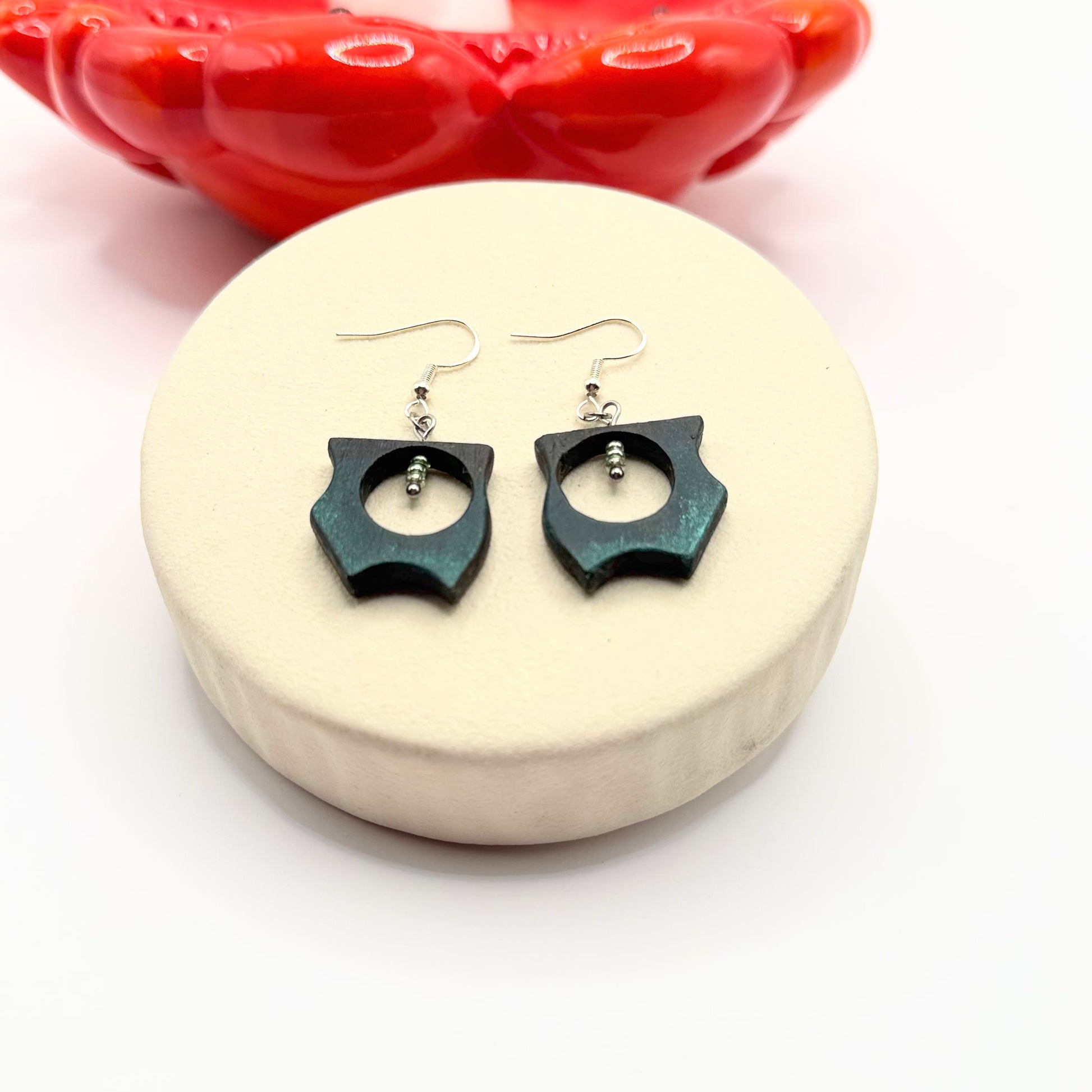 Close view of bog oak dangle earrings with soft green tinted sides