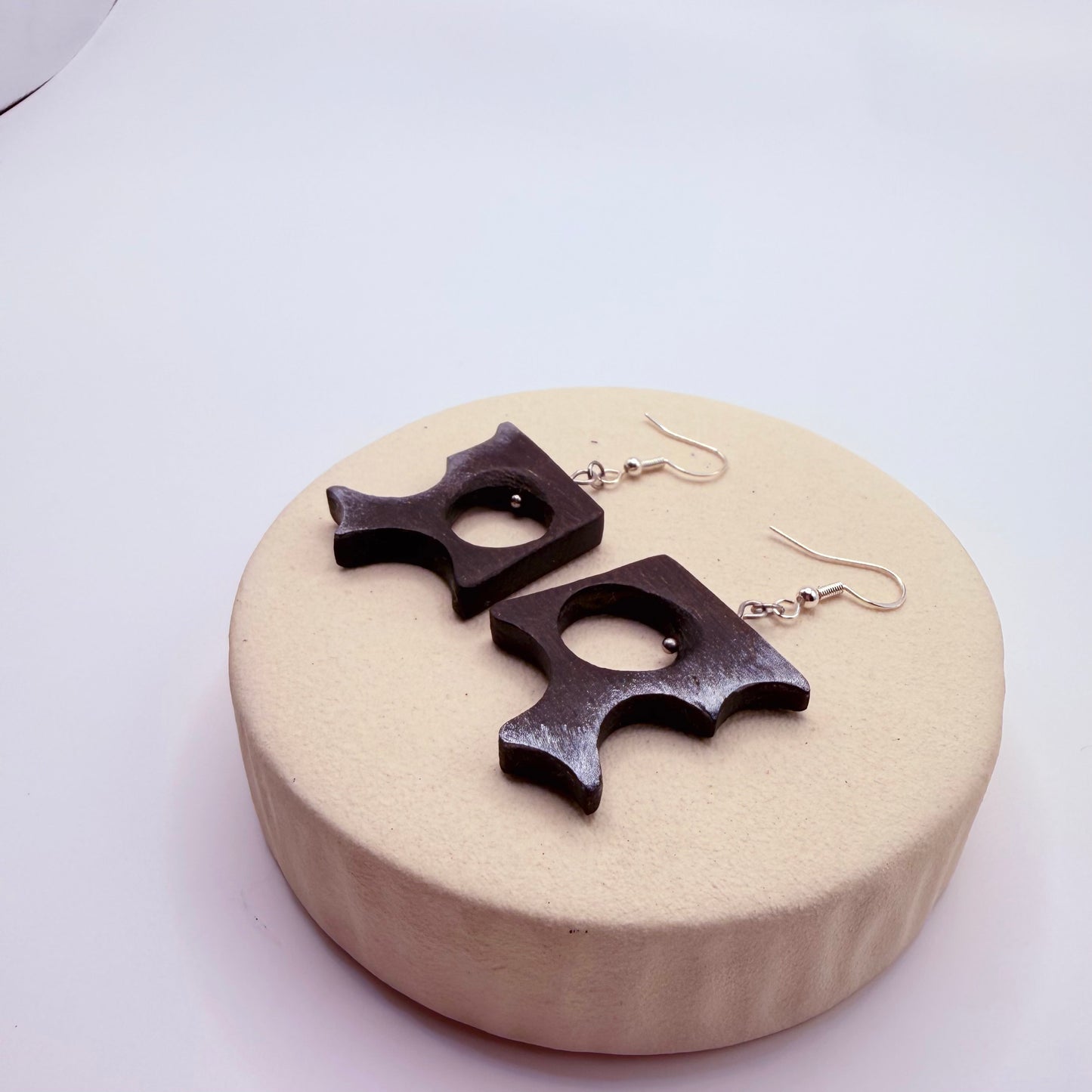 Close-up of sculptural bog oak earrings showing natural wood texture