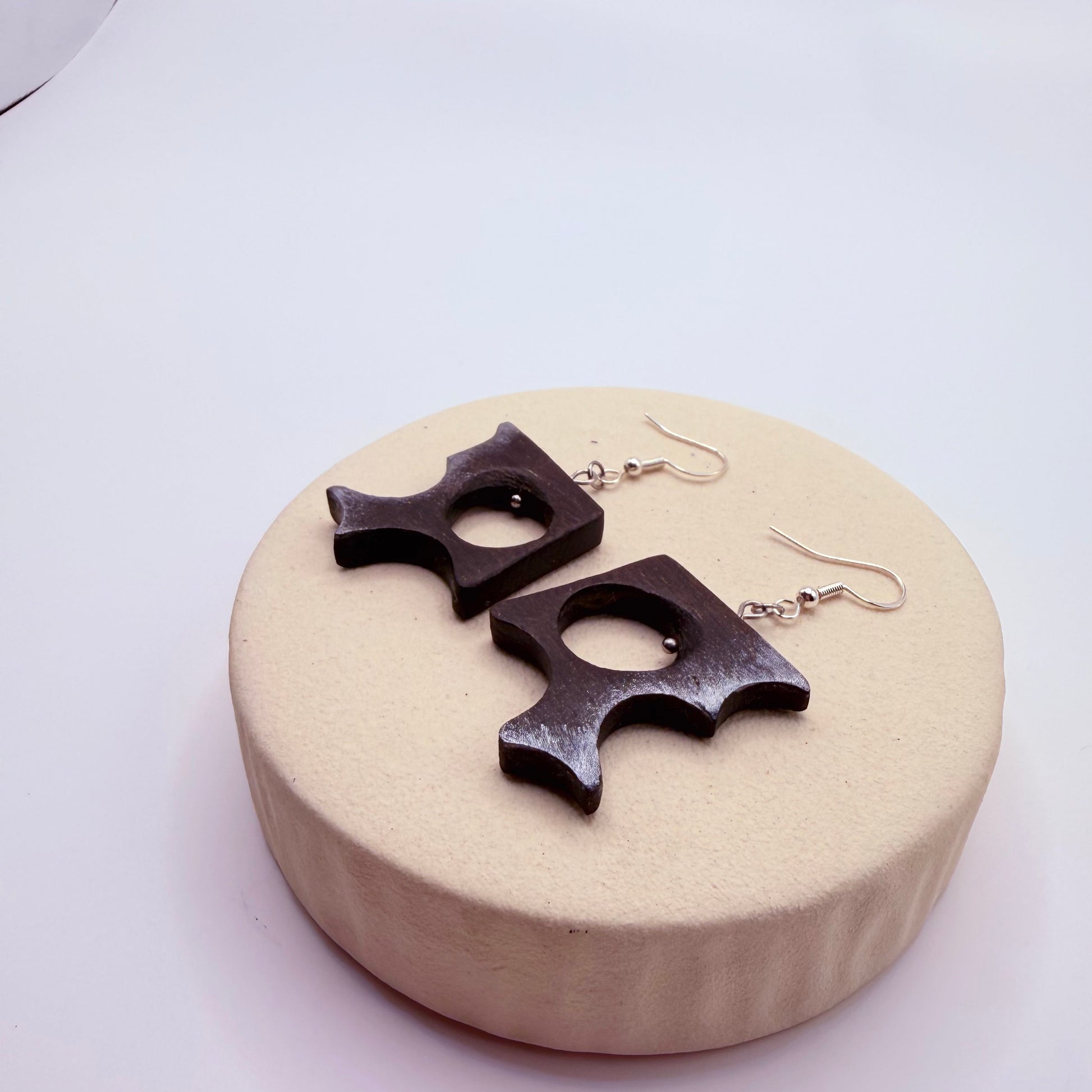 Close-up of sculptural bog oak earrings showing natural wood texture