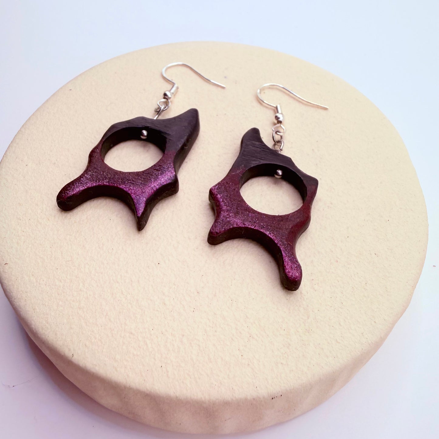 Close-up of handmade bog oak earrings showing organic sculptural shape