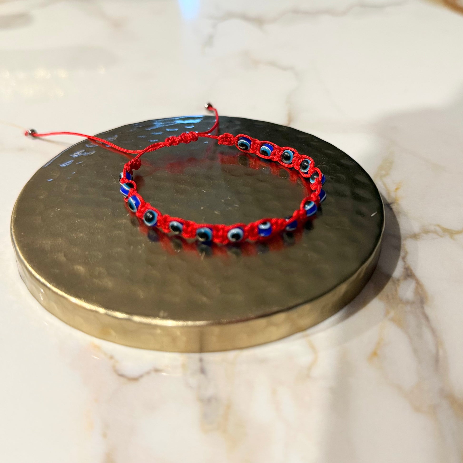 Red and blue beaded bracelet on a metallic surface with a marble background