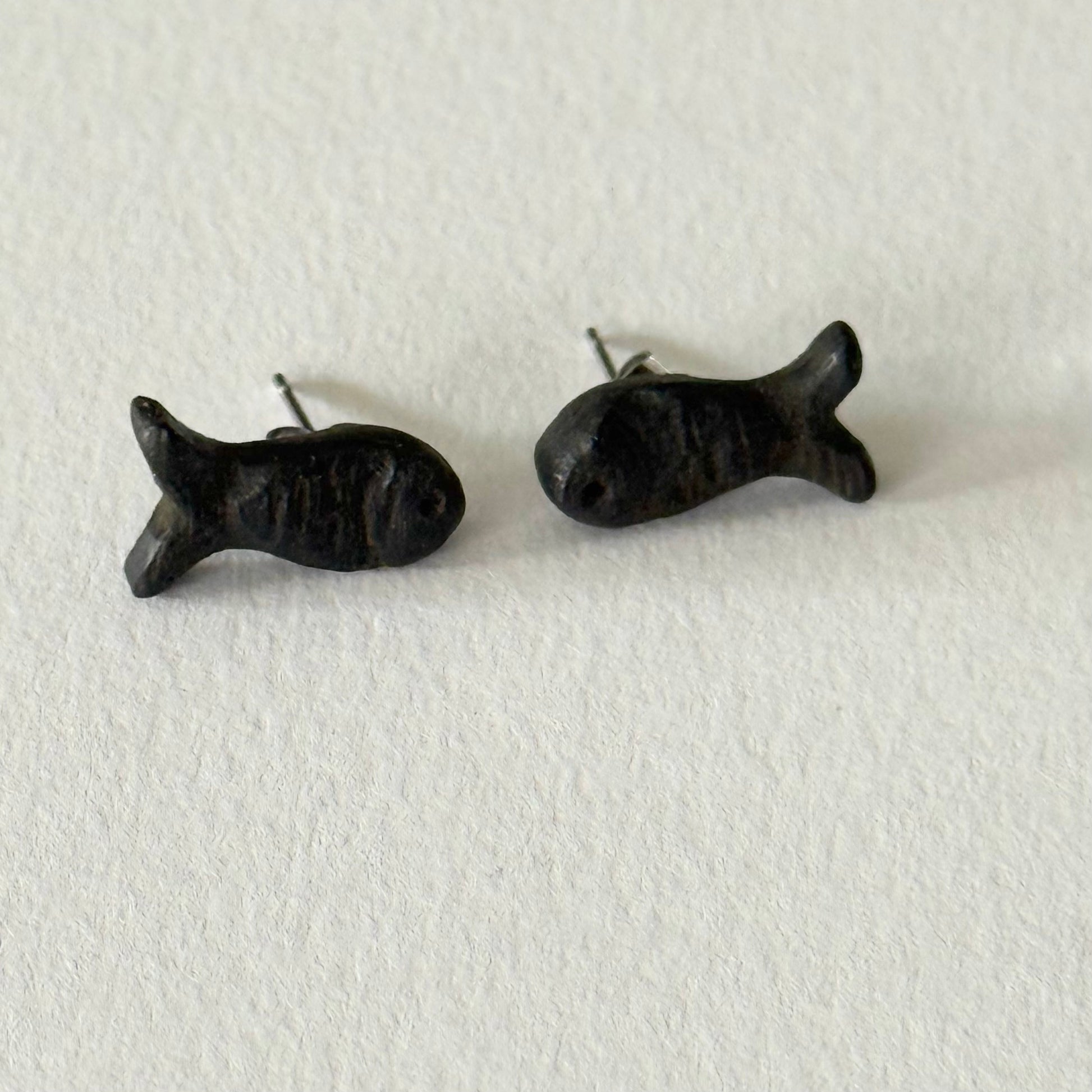 Black fish-shaped earrings on a white background