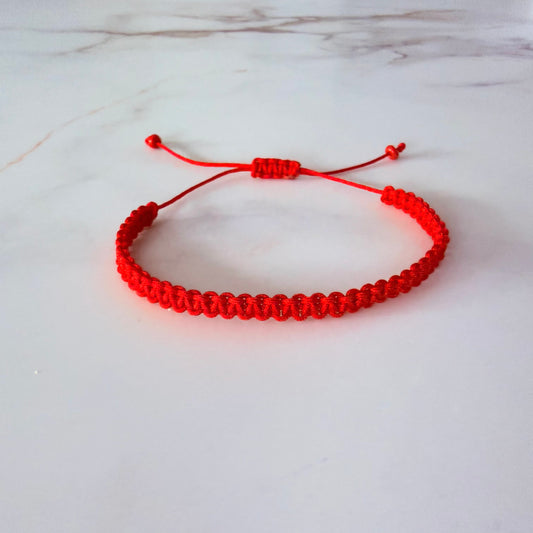 Red bracelet on a white marble surface