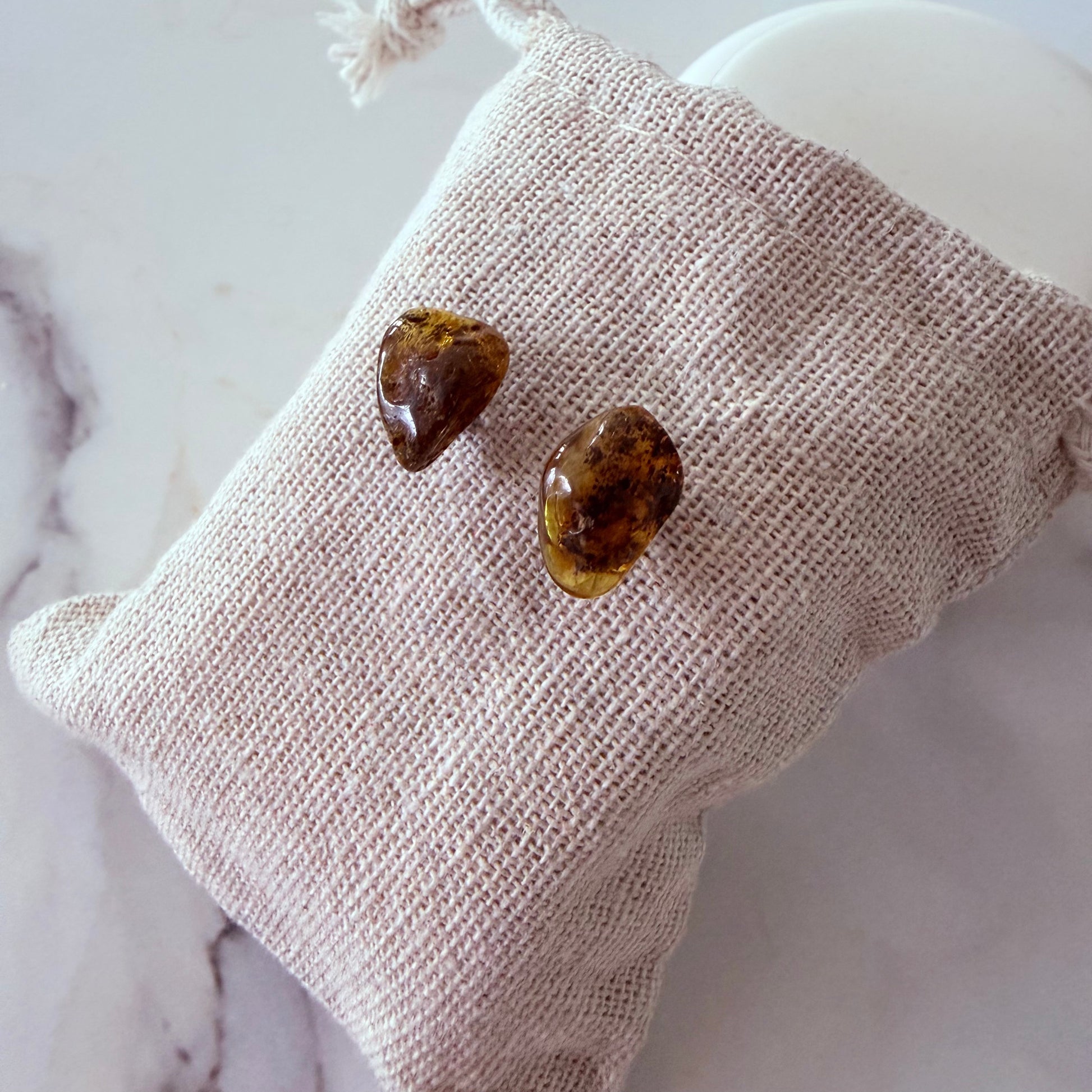 Heart-shaped stones on a textured beige pillow with a marble background