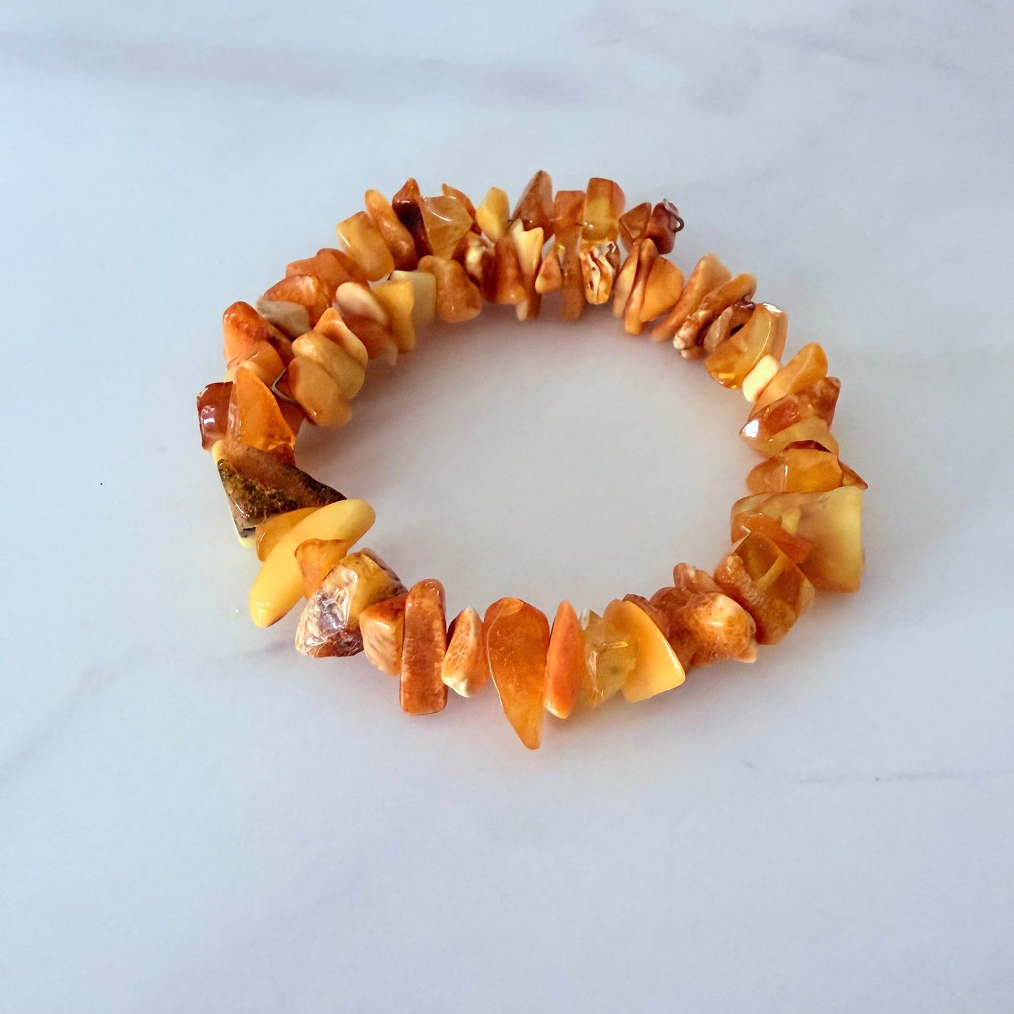 Bracelet made of amber-colored stones on a white background