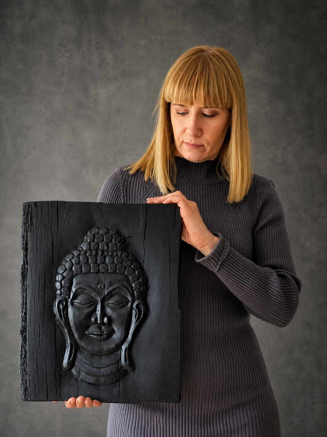 Handmade bog oak Buddha sculpture held by the artist, carved from 3000-year-old Irish wood