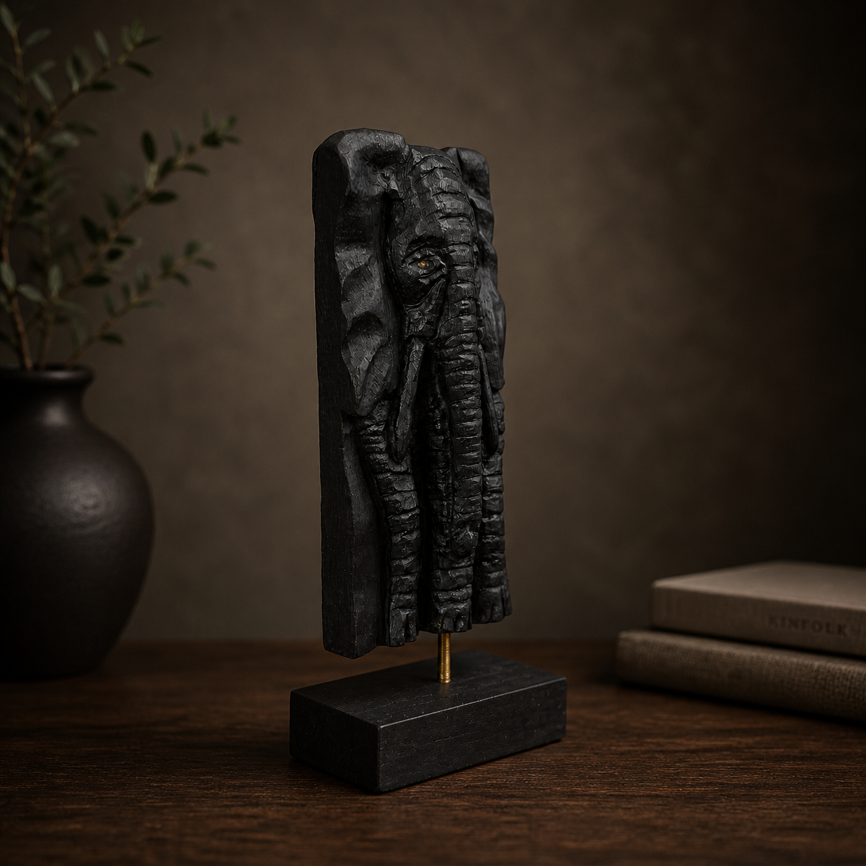 Decorative sculpture on a stand with a vase and books in the background