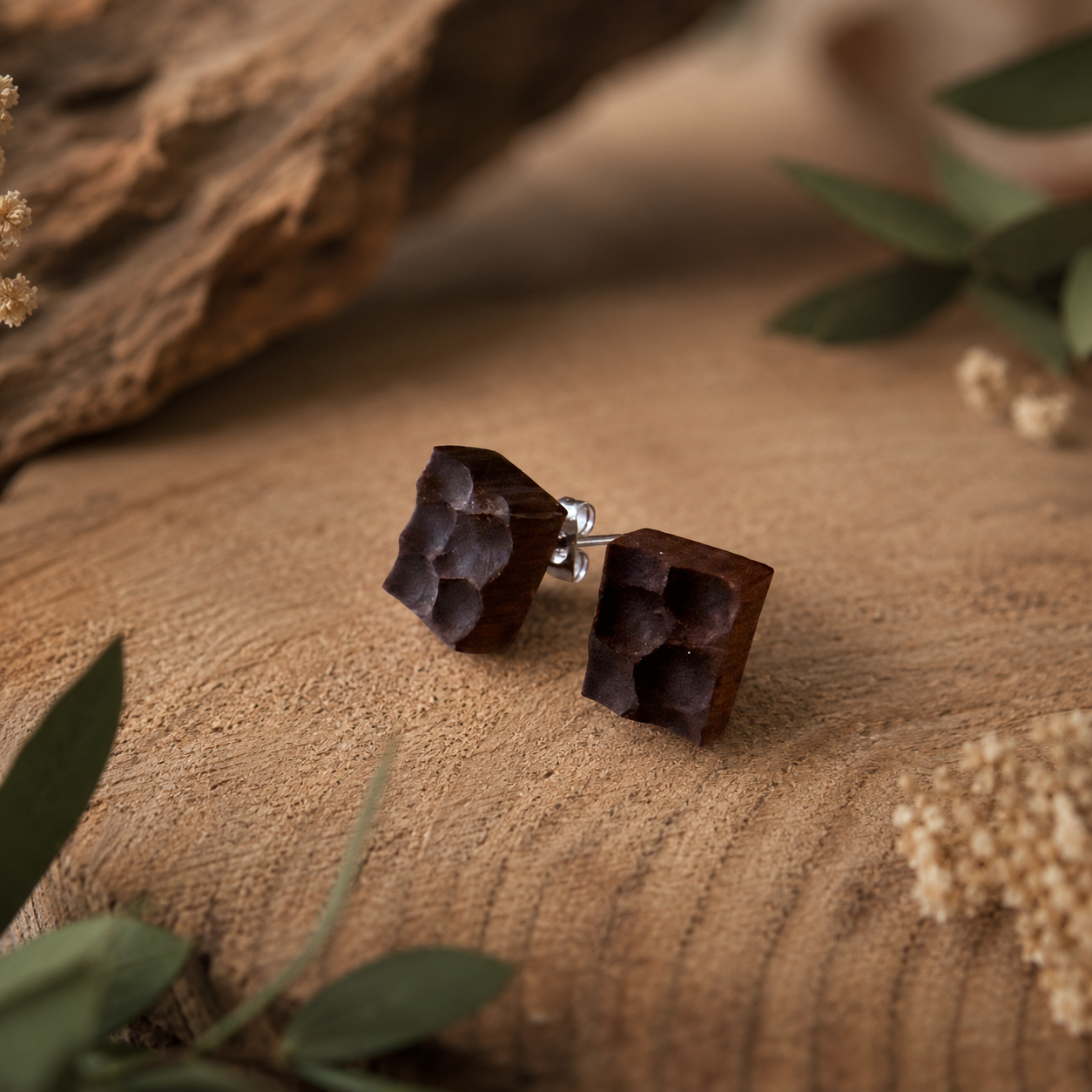 Wooden earrings on a wooden surface with natural elements