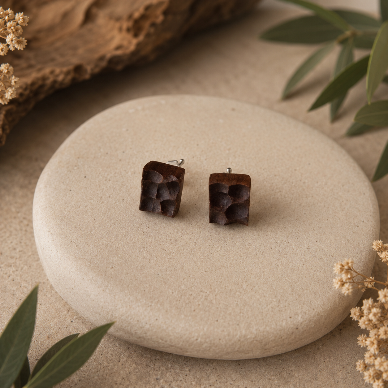 Square earrings on a stone with natural elements
