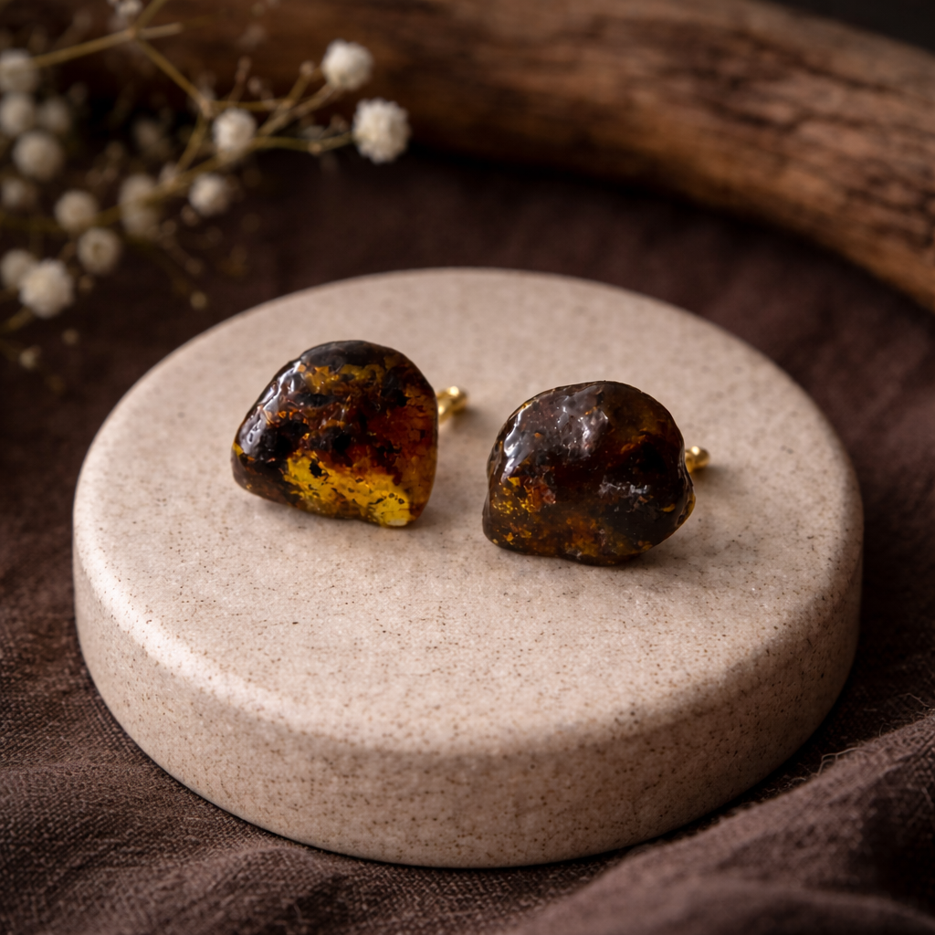 Pair of amber stone earrings on a round stone surface with a natural background.