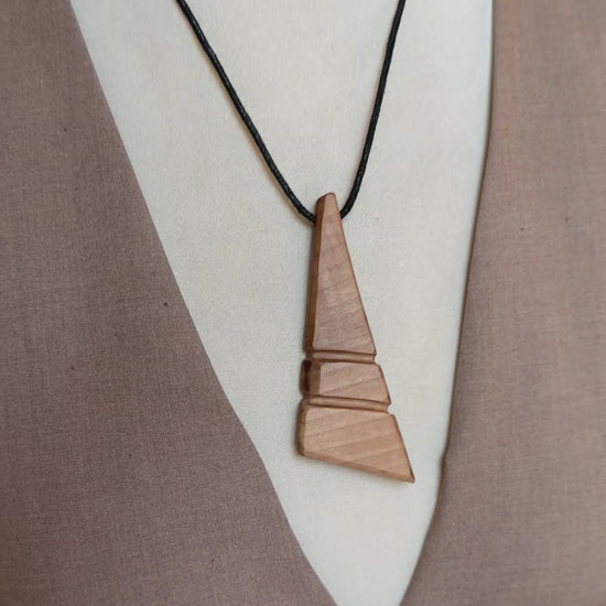 Close-up of handmade apple wood pendant showing natural wood texture and smooth finish