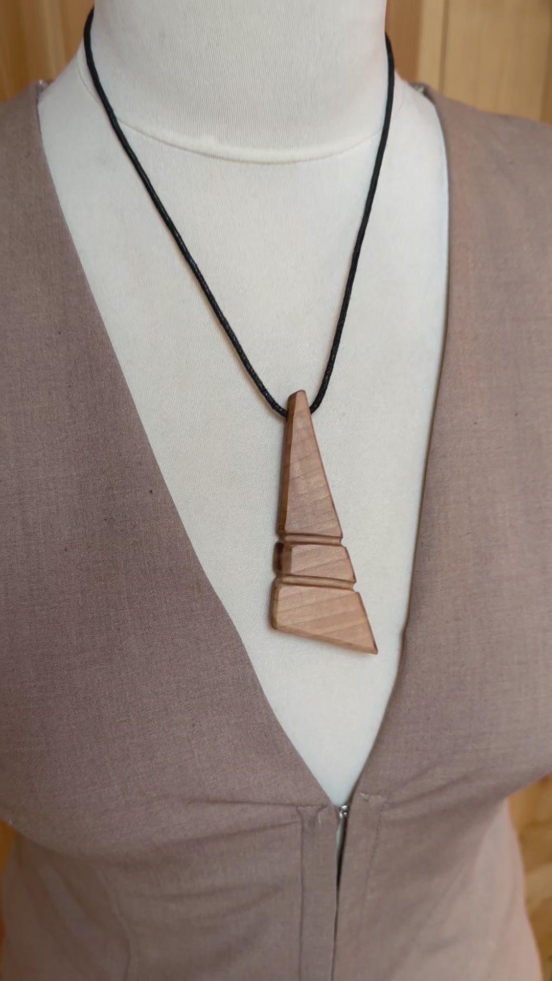 Close-up of handmade apple wood pendant showing natural wood texture and smooth finish