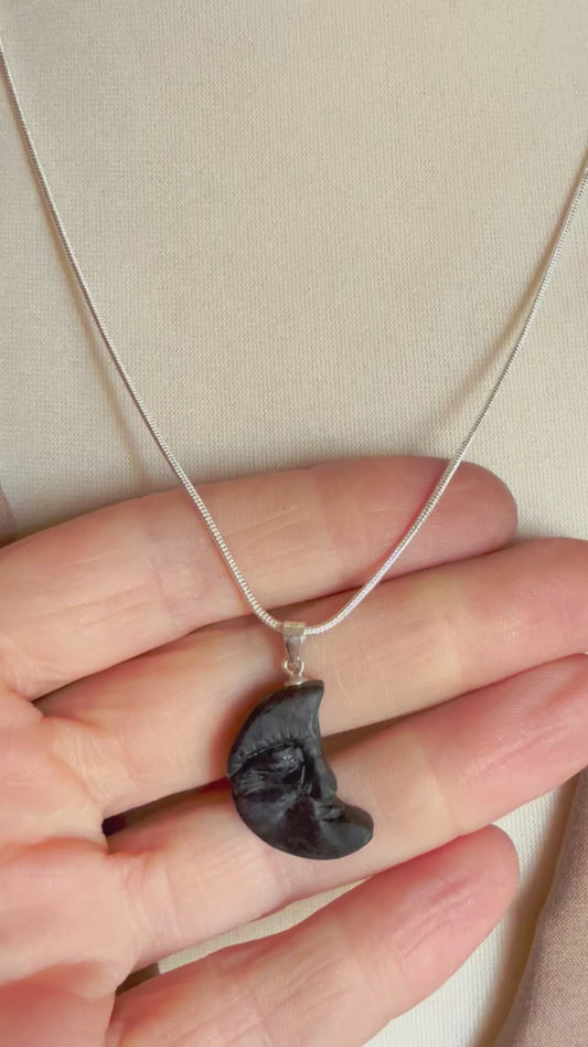 Close-up of black wooden moon necklace with Celtic forest style
